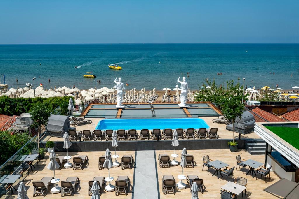 a view of a pool with chairs and the beach at Simus Beach Hotel in Side