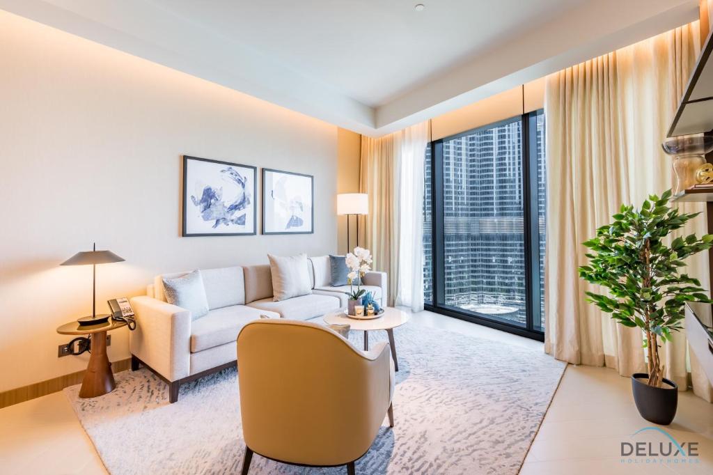una sala de estar con un sofá y una mesa en Elegant 2BR Apartment at The Address Residences Dubai Opera, Downtown Dubai by Deluxe Holiday Homes, en Dubái