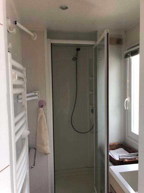 une salle de bain avec une douche avec une porte vitrée dans l'établissement mobil home 6 personnes a SAMOENS, à Samoëns