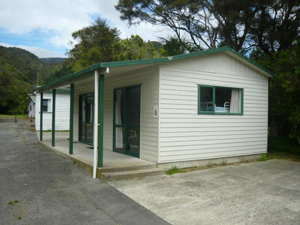 a small white building with a green roof at Alexanders Holiday Park in Picton
