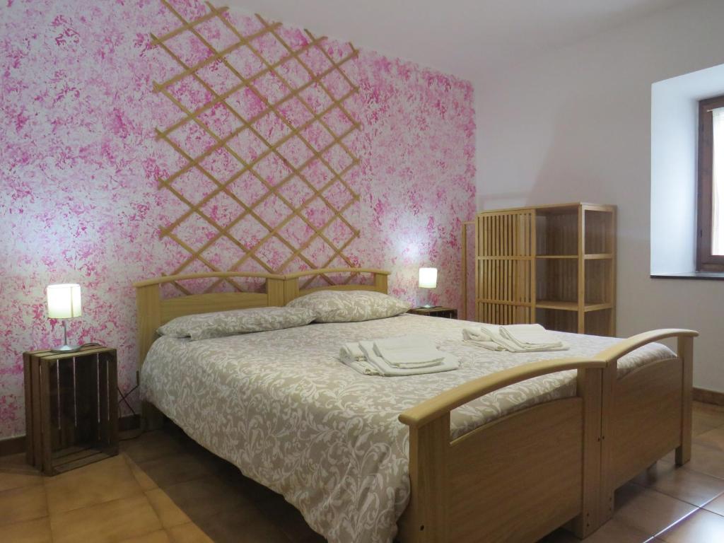 1 dormitorio con 1 cama con pared de color rosa en Marta's house, en Prebernardo