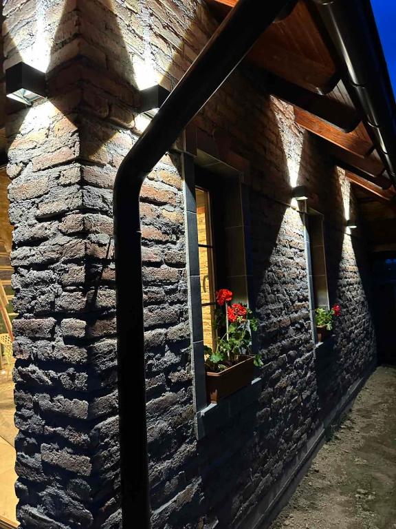 a stone building with a window with flowers in a window box at Charming place in the nature-Casita Iris in Bijeljina
