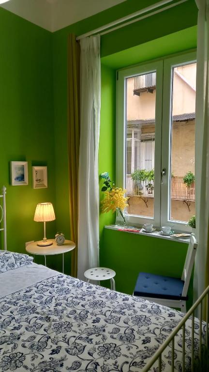 zieloną sypialnię z łóżkiem i oknem w obiekcie B&B Stella Scugnizza w mieście Neapol