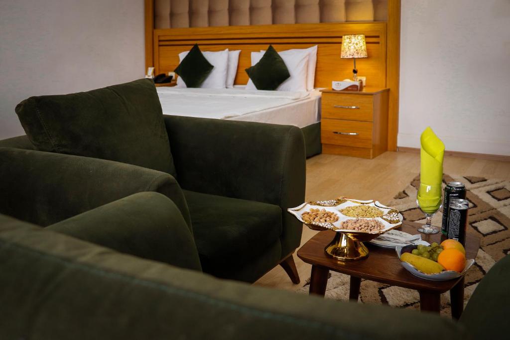 ein Hotelzimmer mit einem Bett und einem Couchtisch in der Unterkunft Arg Hotel in Herat
