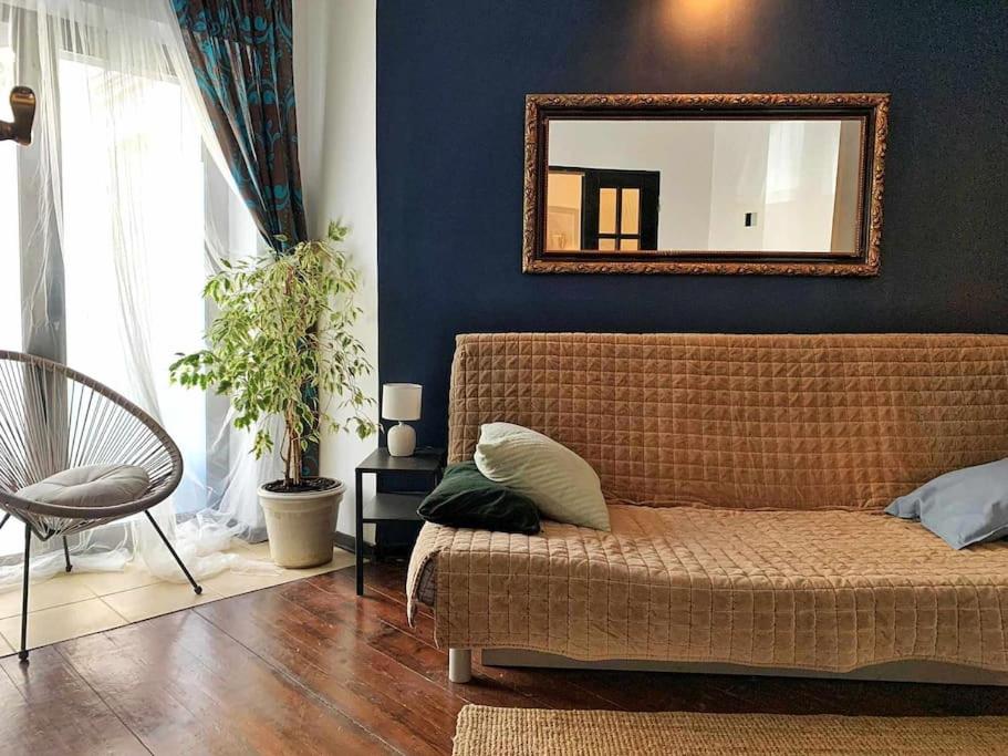 un soggiorno con un divano e uno specchio di Wygodny apartament Piotrkowska a Łódź