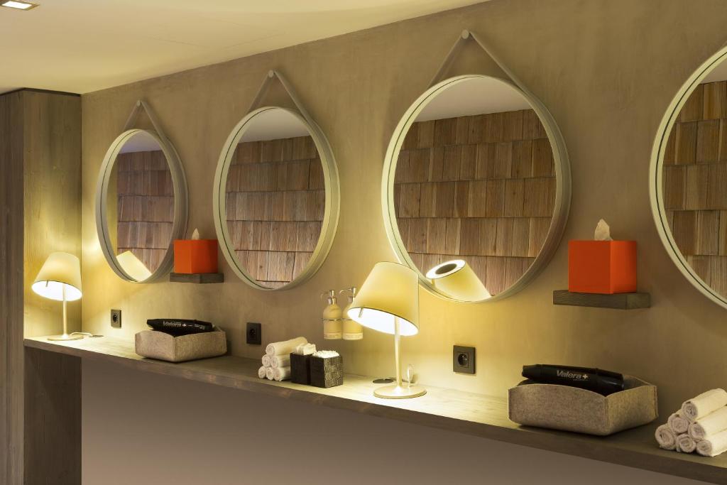 a room with three mirrors and a shelf with lamps at Heliopic Hotel & Spa in Chamonix