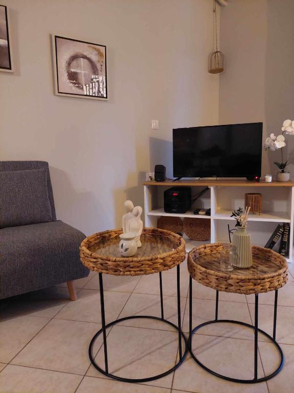 a living room with two tables in front of a tv at Boho Zen Retreat in Agia Pelagia