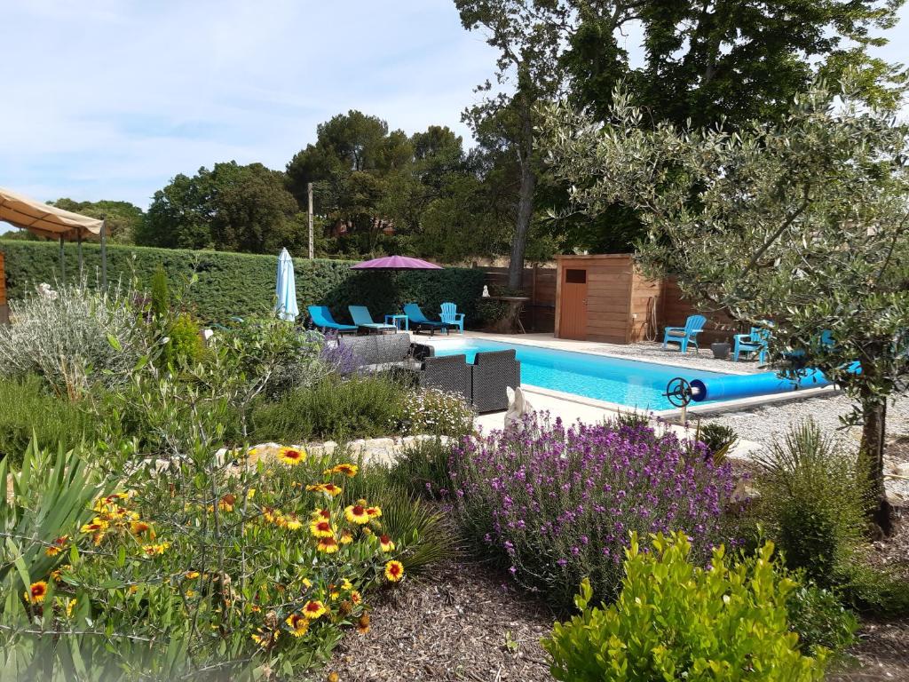- une piscine dans un jardin fleuri dans l'établissement gîte neuf 