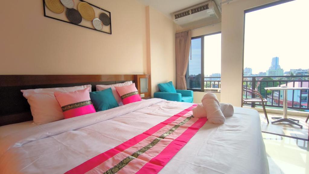 a bedroom with a large bed and a balcony at Lucky Buako Hotel Patong in Patong Beach