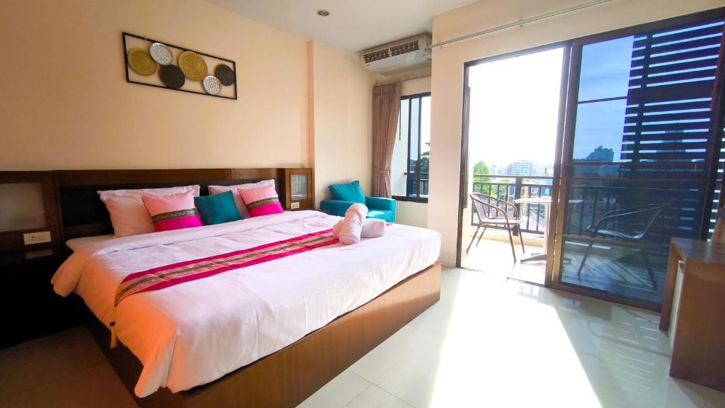 a bedroom with a large bed and a balcony at Lucky Buako Hotel Patong in Patong Beach