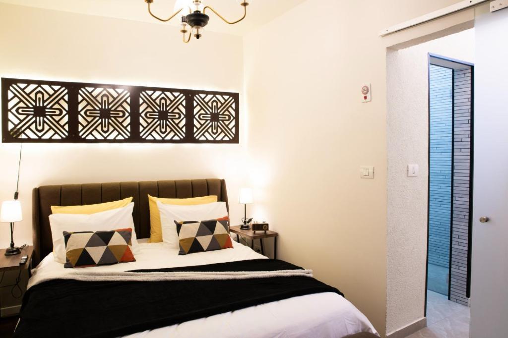 um quarto com uma cama com almofadas pretas e brancas em House in Shalma em Tel Aviv