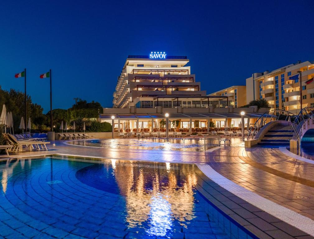 a pool in front of a building at night at Savoy Beach Hotel & Thermal Spa in Bibione