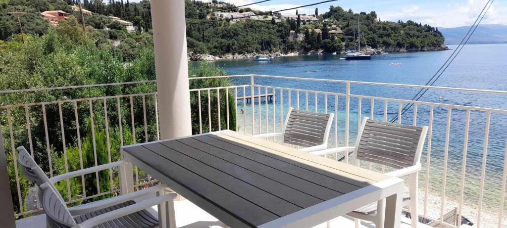a balcony with a table and two chairs and the water at Villa Elsi upper apartment in Kalami
