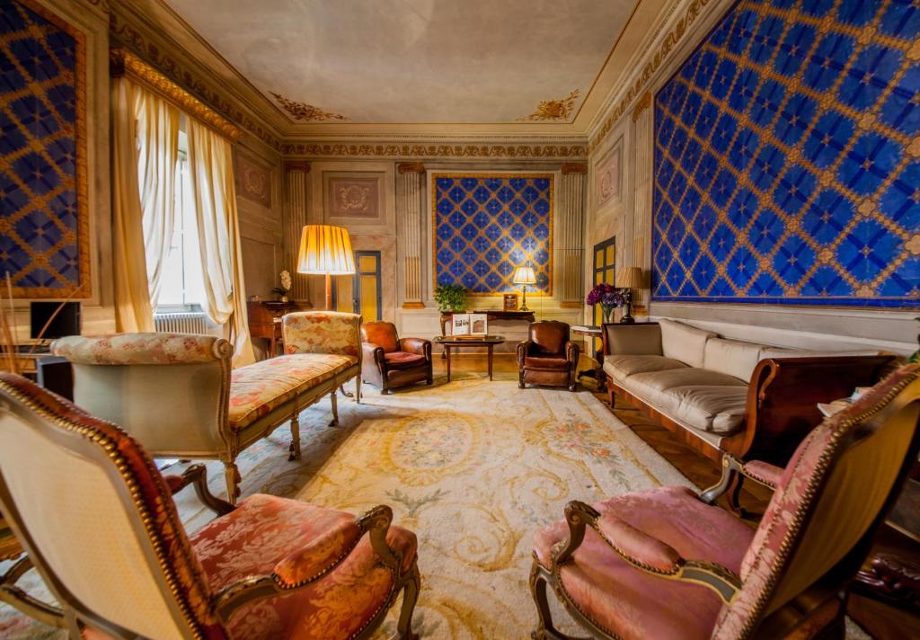 ein großes Wohnzimmer mit Stühlen und einem Sofa in der Unterkunft Palazzo Rocchi B&B in Lucca