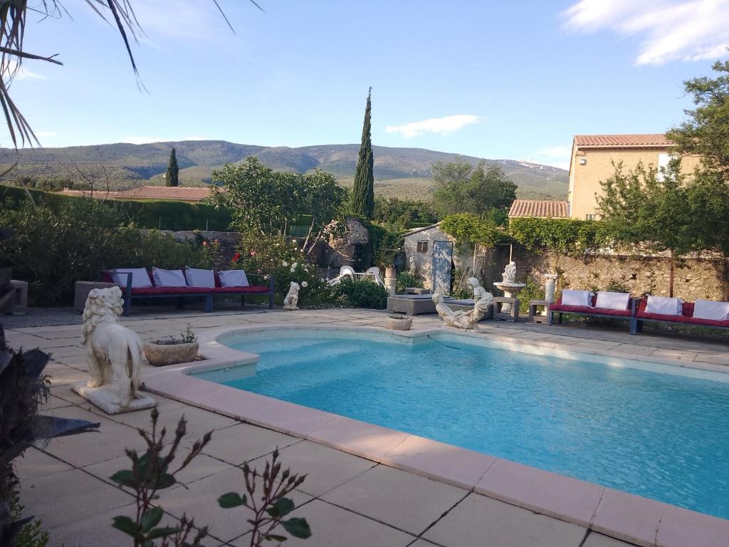 a swimming pool with a lion statue in a yard at Les Gites du Mont Ventoux in Bédoin
