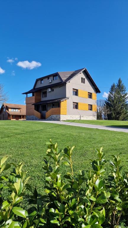 ein großes Haus mitten auf einem grünen Feld in der Unterkunft 4 Seasons Guest House in Rakovica