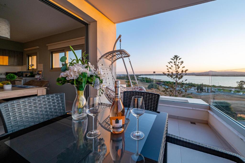 uma sala de jantar com uma mesa de vidro com garrafas de vinho em Majestic Sunset Salt Lake Views 300m From Beach em Larnaka