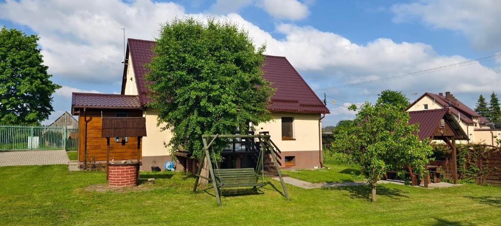 a house with a tree and a swing at Kaszubskie Siedlisko Szkodnikówka in Skwierawy