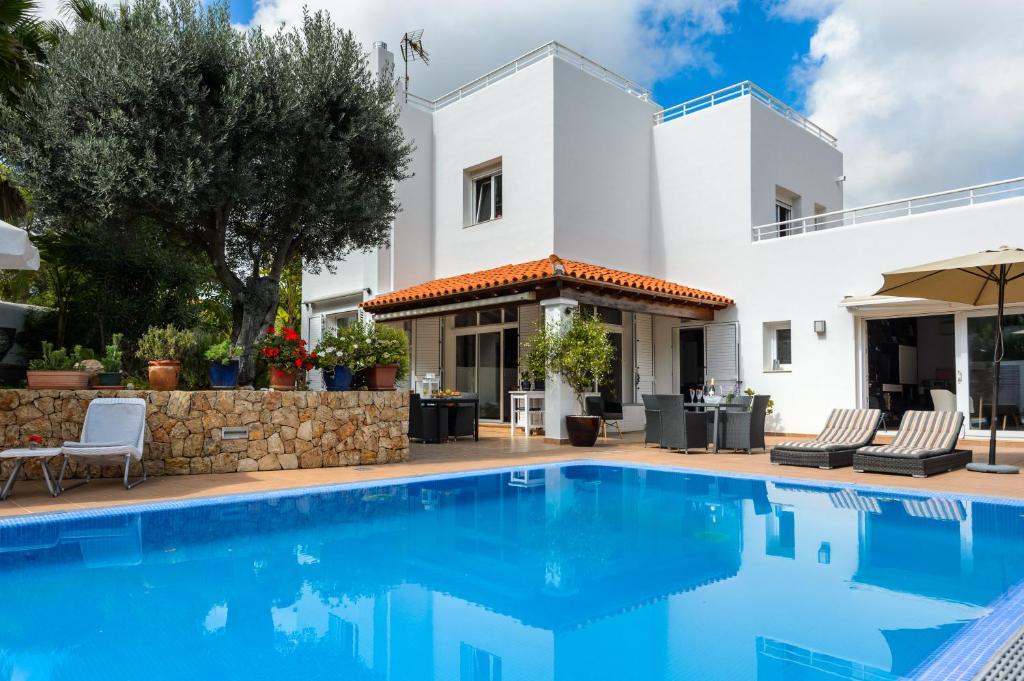 uma villa com piscina em frente a uma casa em Villa Blanca Santa Eulalia em Santa Eulária des Riu