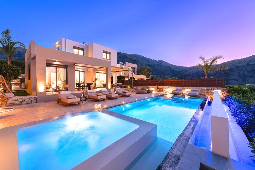 une villa avec une piscine la nuit dans l'établissement Minoas Villas Heated Pool, à Kournás