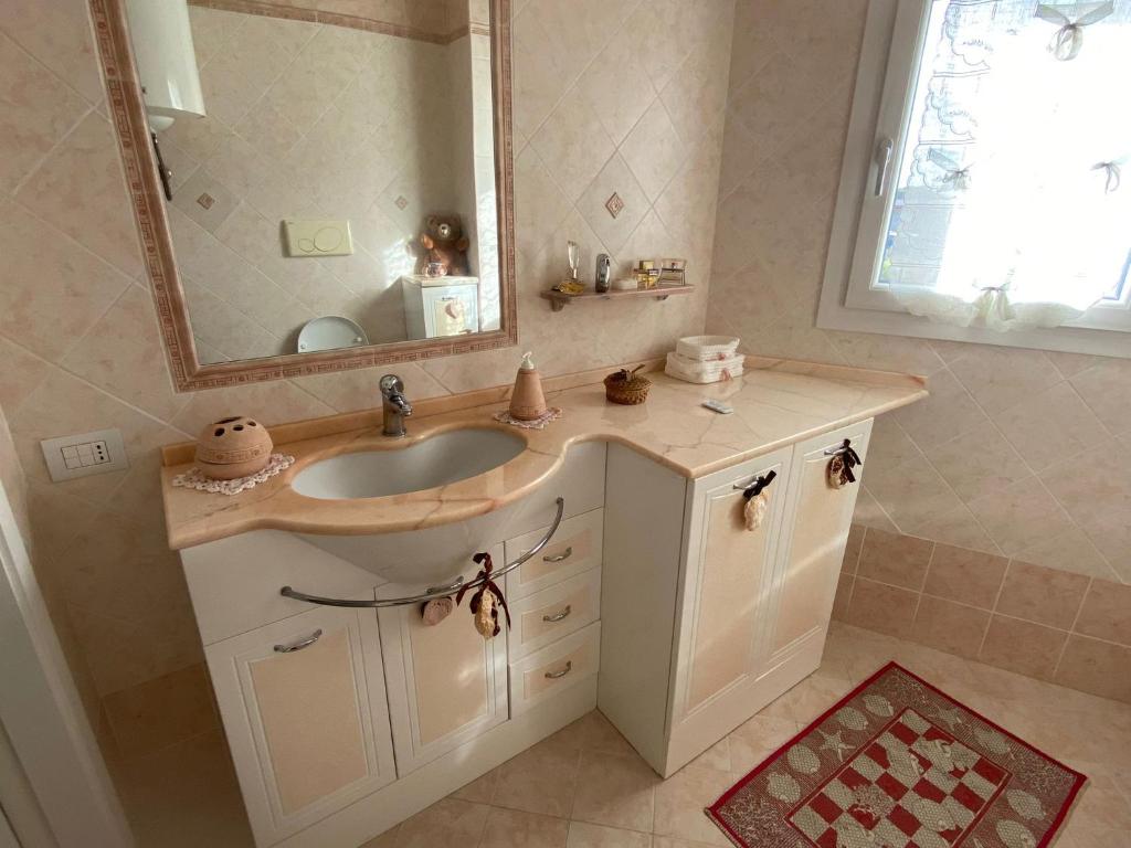 un bagno con lavandino e specchio di Amicizia a Valledoria