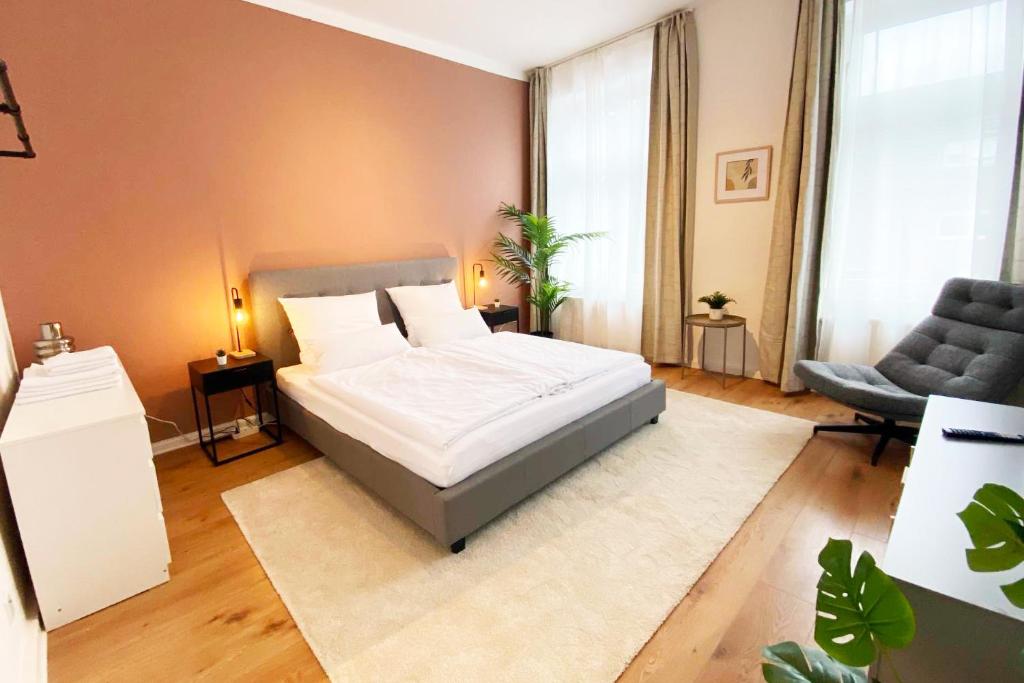 メンヒェングラートバッハにあるModernes City-Apartment in Mönchengladbachのベッドとソファと椅子のある寝室