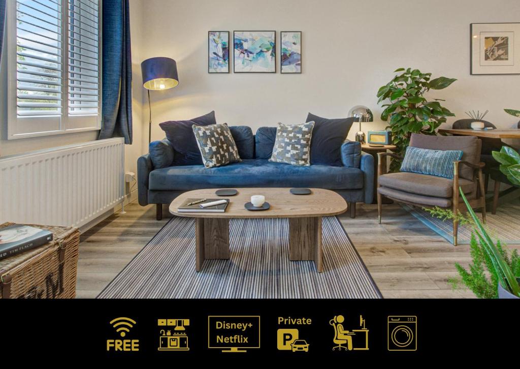 a living room with a blue couch and a coffee table at Stylish, business traveller friendly apartment, with free parking and Netflix in Farnborough