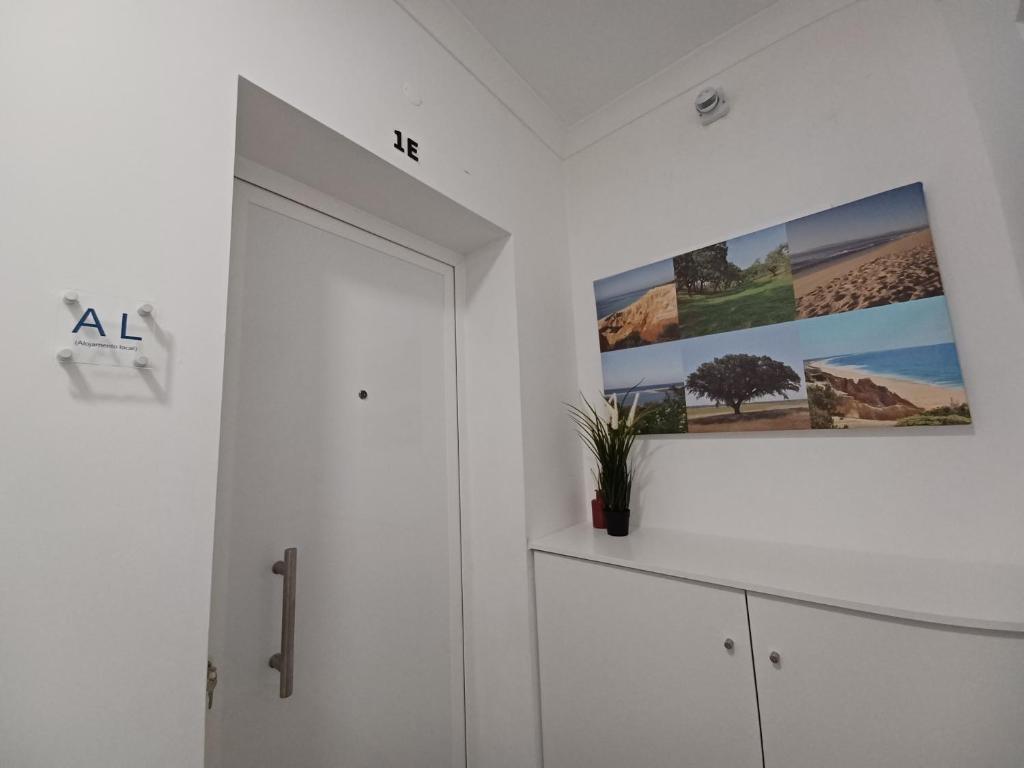 een witte kamer met een schilderij aan de muur bij AL Encanto in Grândola