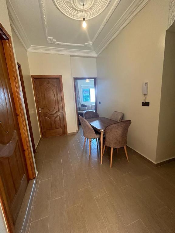 a dining room with a table and chairs at Appartement à Houma, proche Port Tanger Med in Dalia