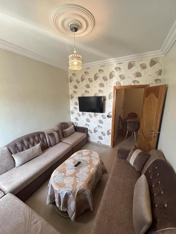 a living room with a couch and a table at Appartement à Houma, proche Port Tanger Med in Dalia