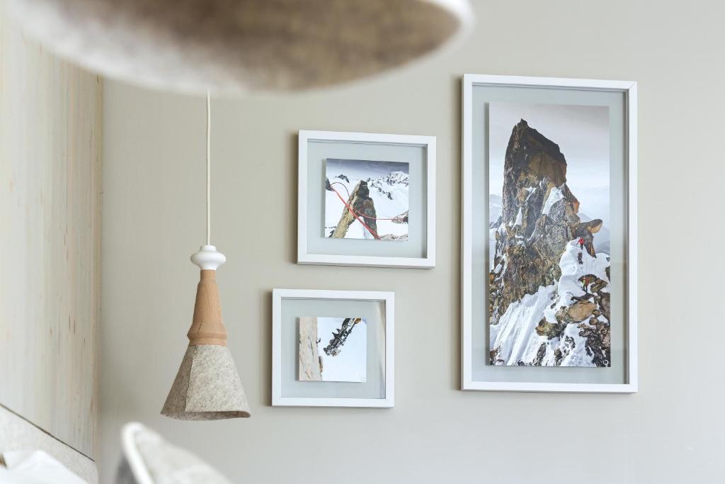 a row of framed pictures on a white wall at Heliopic Hotel & Spa in Chamonix