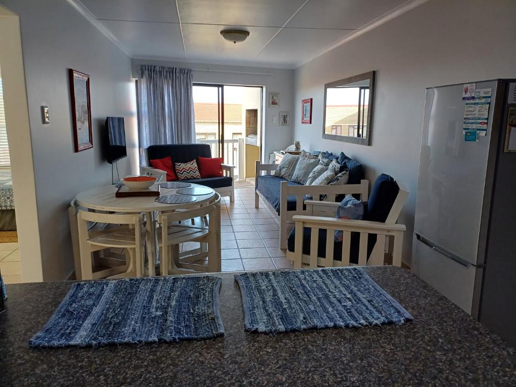 莫塞尔湾Hartenbos - Bayview 230m from beach的客厅里有一张沙发和一张桌子。