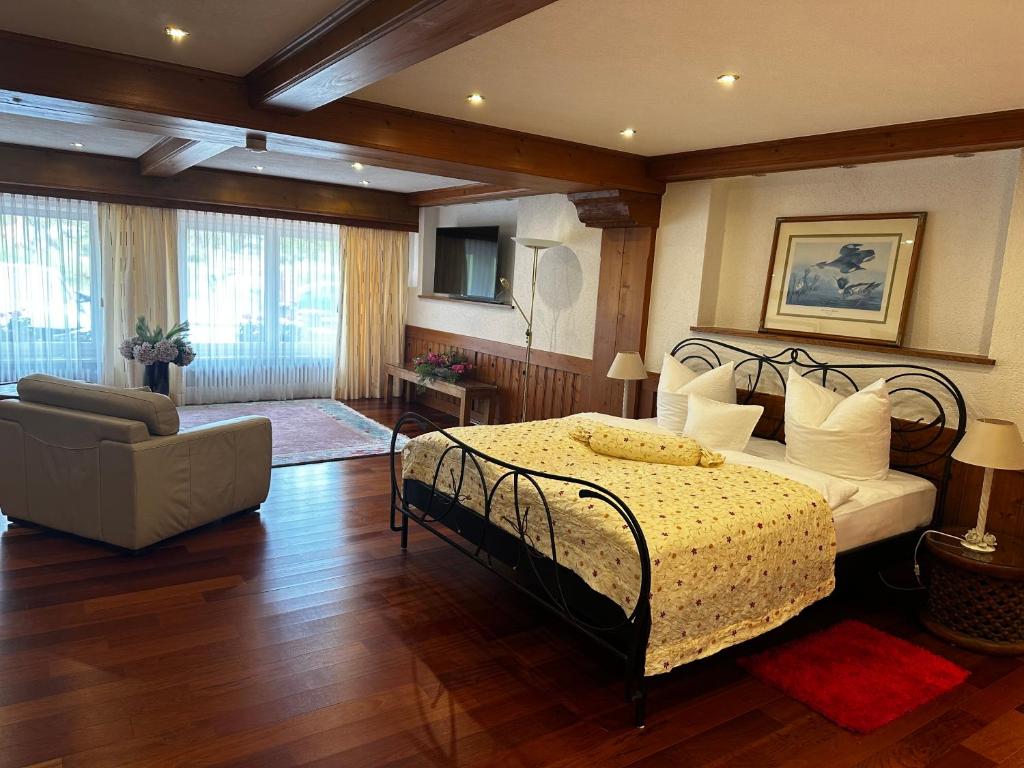 ein Schlafzimmer mit einem Bett, einem Sofa und einem Stuhl in der Unterkunft La Felicita 7 in Schluchsee