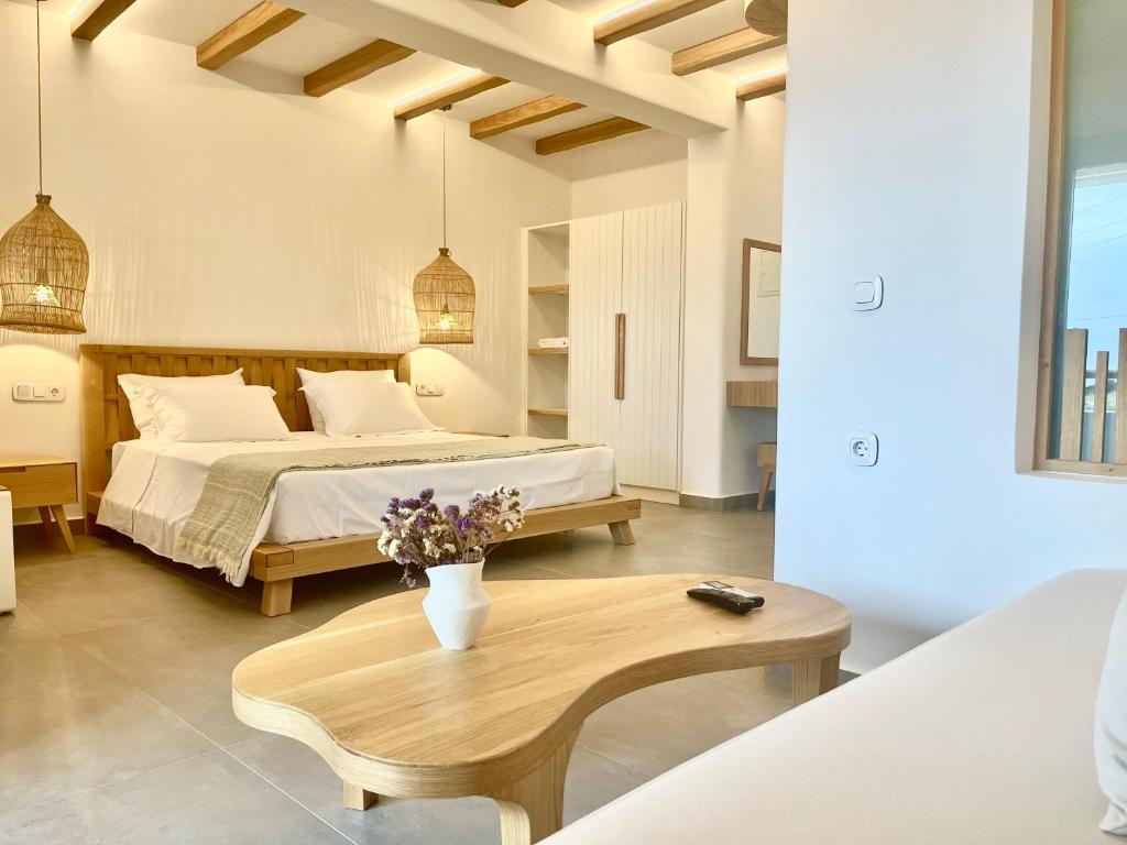 1 dormitorio con cama y mesa de centro en SOHOROS suites en Skhoinoússa