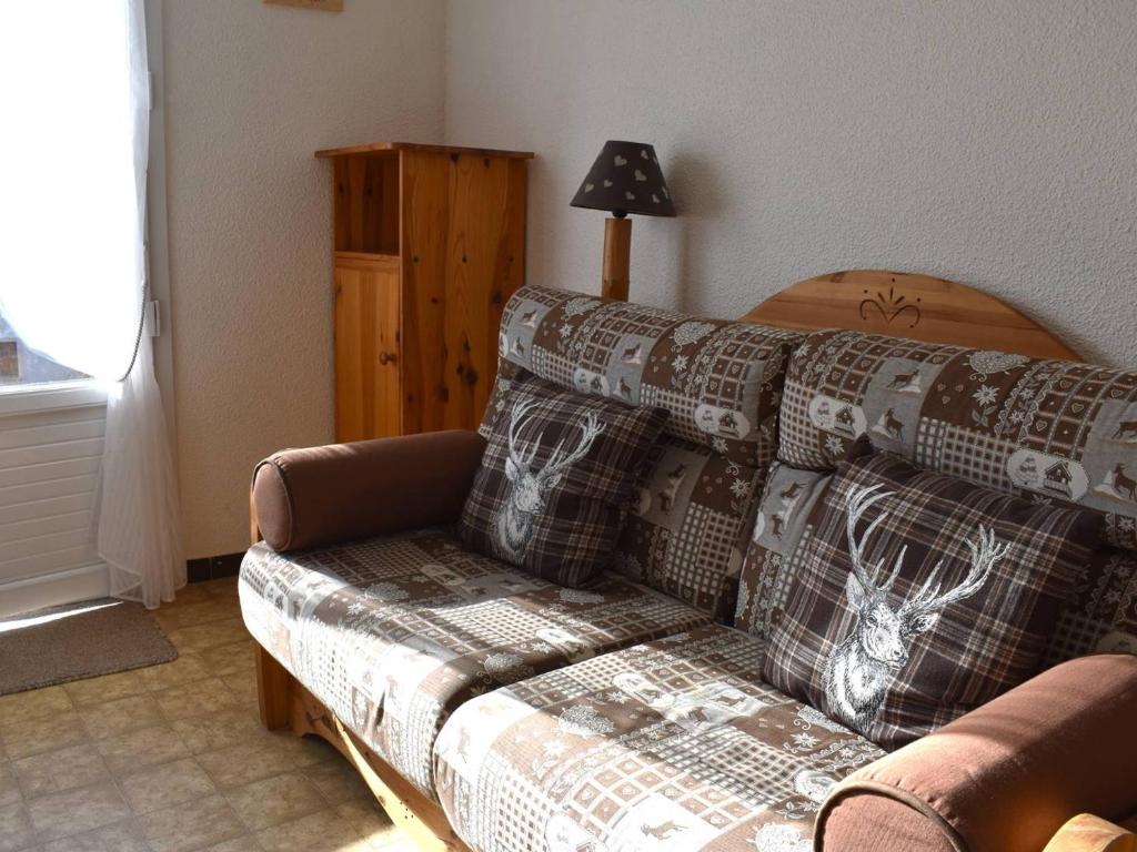 un salon avec un canapé avec une couverture dans l'établissement Appartement Confortable 3 Pièces, Jardin, Exposé Sud, 6 Pers, Parking – Font-Romeu - FR-1-580-23, à Font-Romeu-Odeillo-Via