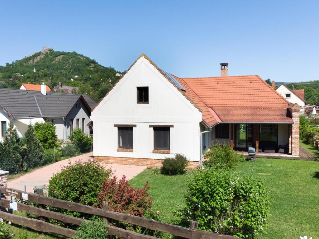 a white house with a red roof at Rusztikus Nyaralóház in Szigliget