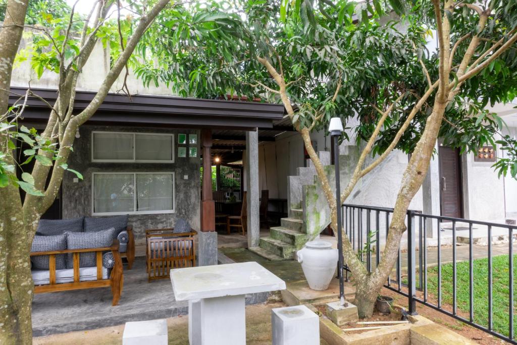 uma casa com um alpendre com um banco e árvores em Dollyz Home - Sri Lanka em Ambalangoda