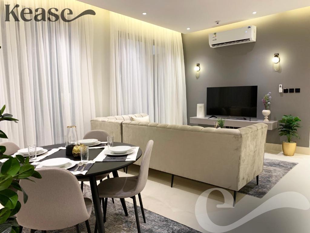 uma sala de estar com uma mesa e um sofá em Kease Tawun A5-2 Royal touch Terrace XZ48 em Riyadh