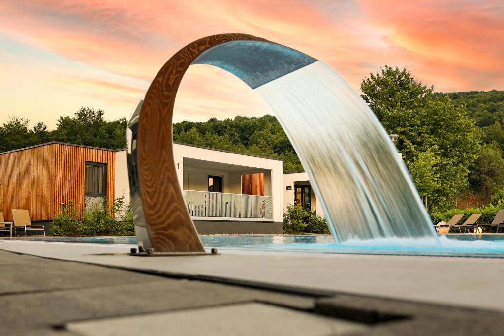 una fontana di fronte a una casa di Mobile Homes Camping Plitvice a Smoljanac