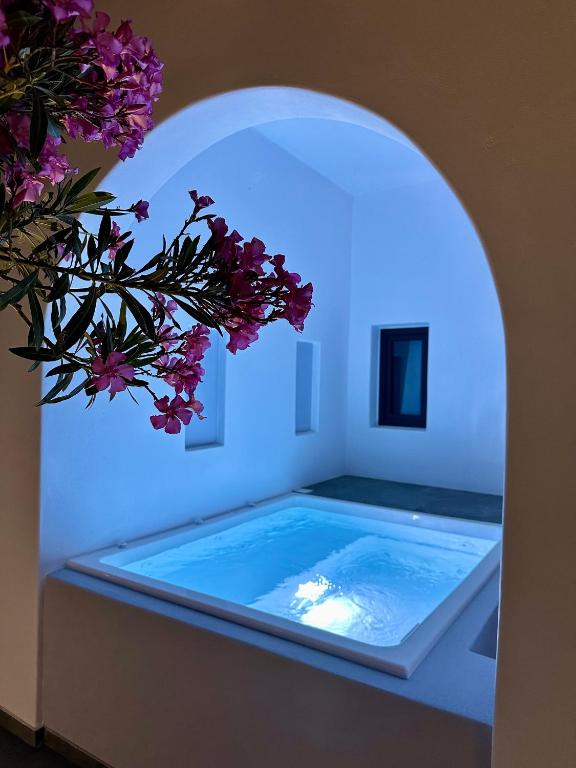a swimming pool with a blue light in a room at Miracles Suites by Anastasia Princess, Adults Only in Perissa