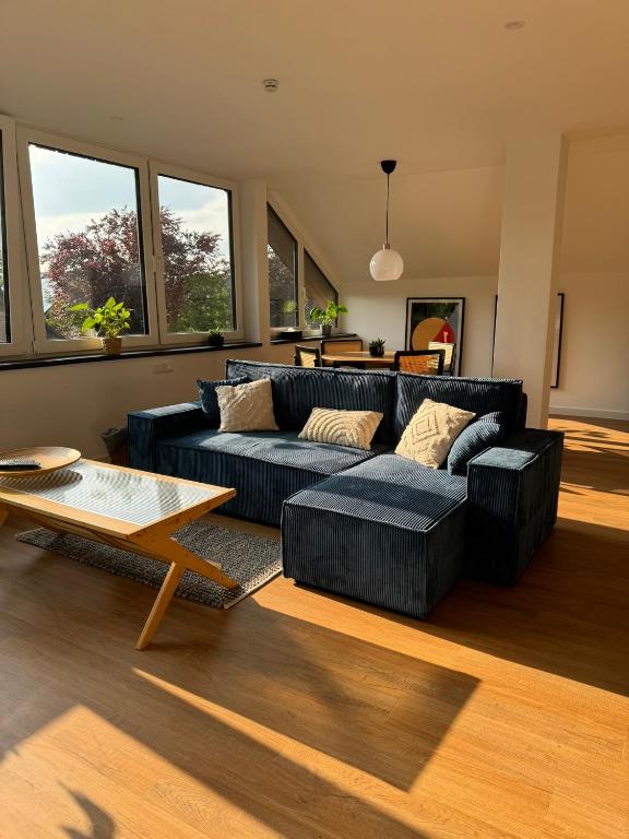 a living room with a blue couch and a table at Stilvolles Apartment mit Waldblick in Bad Bentheim