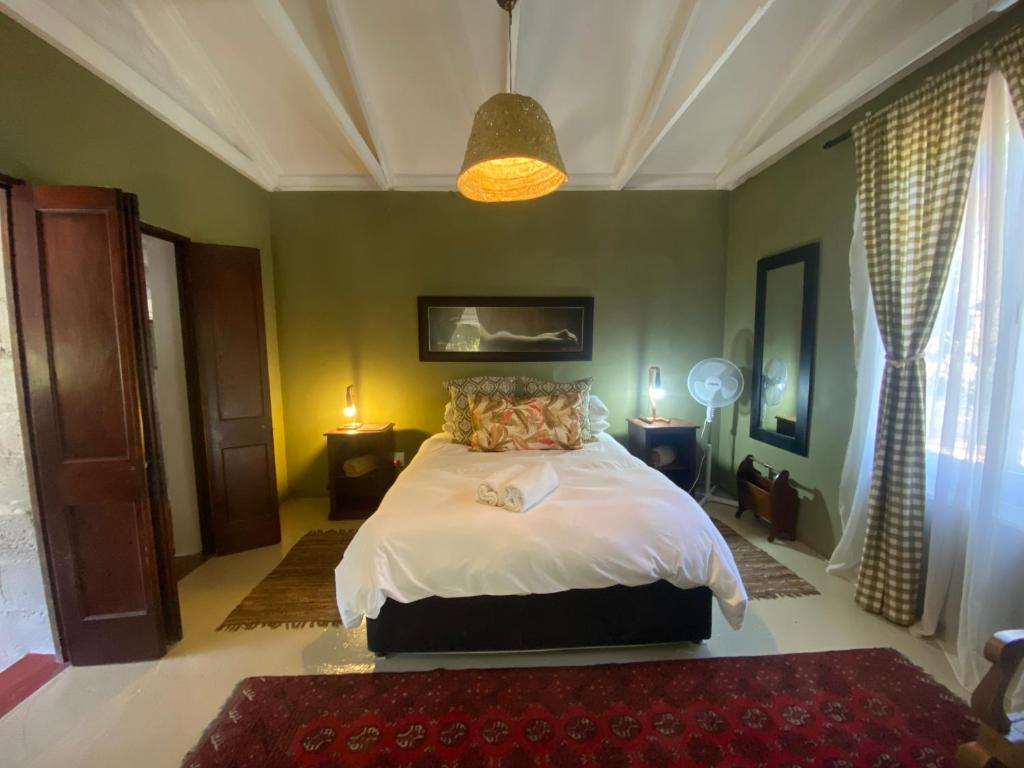 a bedroom with a bed in a room with green walls at The Riverdeck Accommodation and Backpackers in Knysna