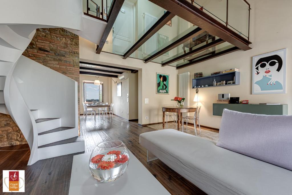 a living room with a white couch and a staircase at Chianti B&B Design infinity pool shared in Pianella