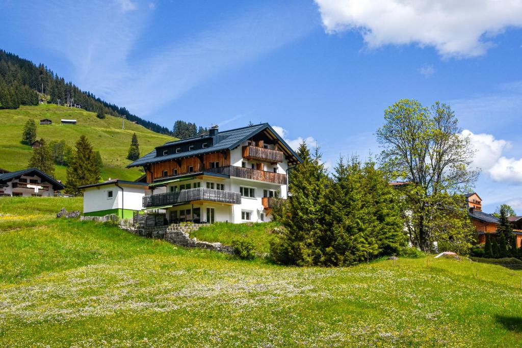 een groot huis op een heuvel in een veld bij Das Kleemanns in Mittelberg