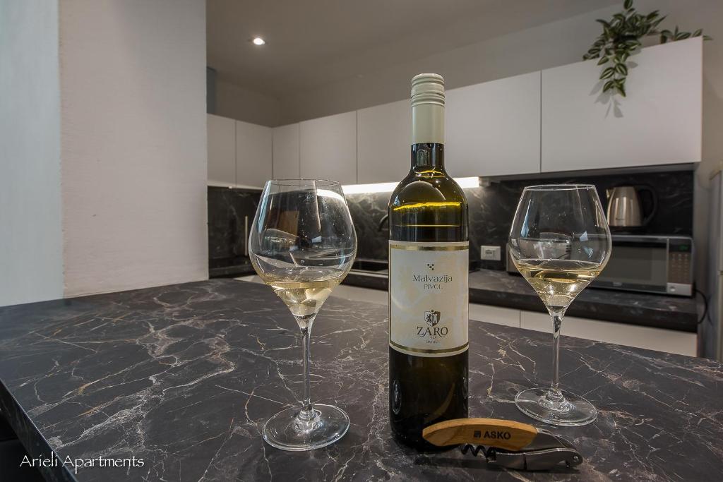 una botella de vino y dos copas de vino en una barra en Arieli Apartments Izola en Izola