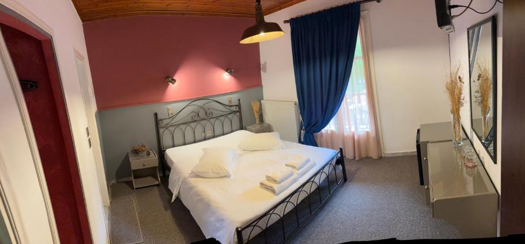 una camera da letto con letto, lenzuola e cuscini bianchi di Guesthouse Sinoi a Vytina