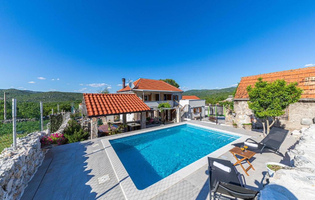 a villa with a swimming pool and a house at Nice Home In Trolokve in Prgomet
