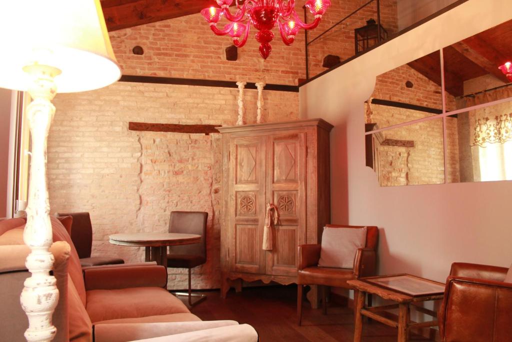 Habitación con sillas, mesa y lámpara de araña. en Rosso Charm B&B, en Venecia
