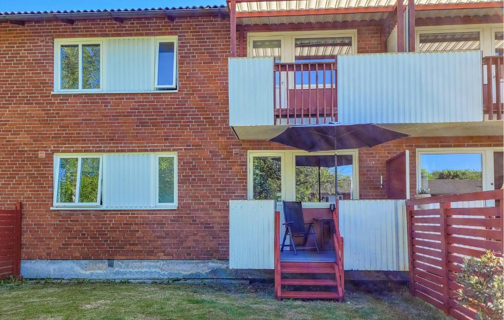 un edificio de ladrillo rojo con una silla azul delante de él en Pet Friendly Apartment In Hyltebruk With Wifi en Hyltebruk
