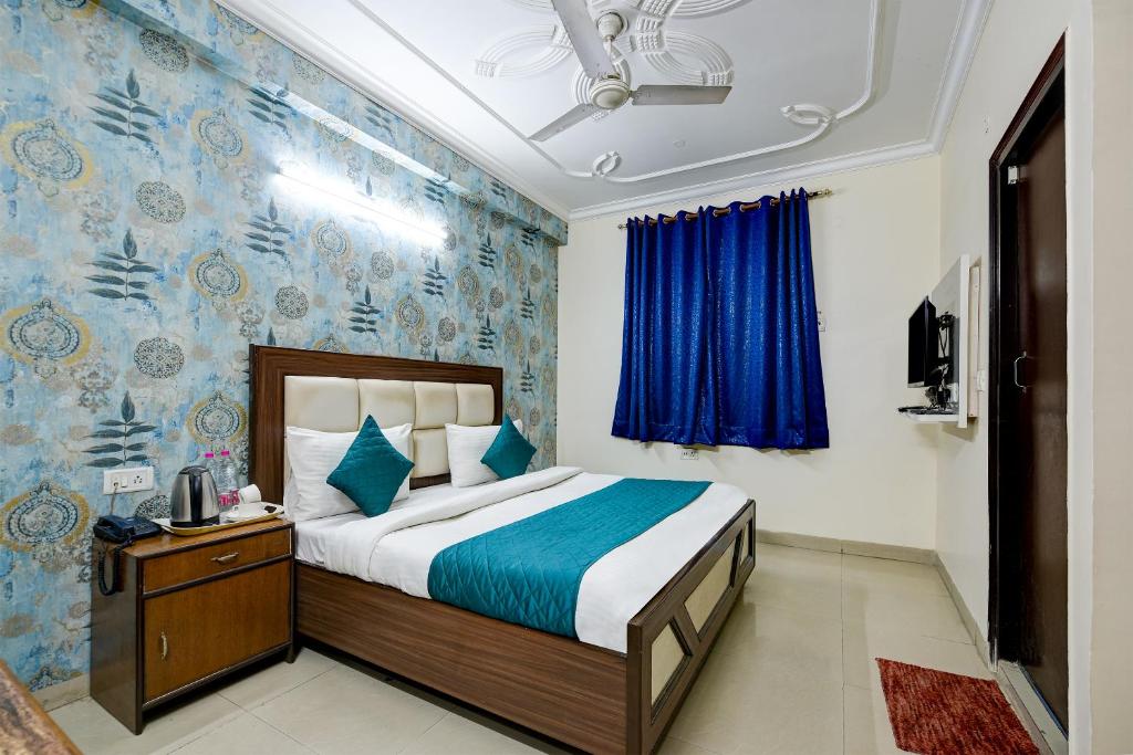 1 dormitorio con cama y pared azul en Arkwood Residency B & B At Airport en Nueva Delhi